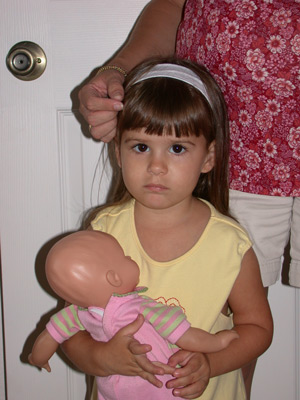 Image - a scared young girl, leaning against her mom's hip for comfort